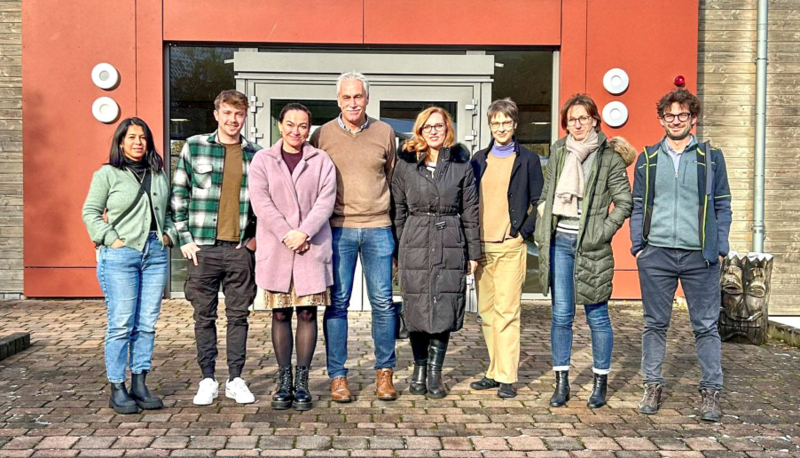 das FOREE-Team steht vor einem Hauseingang.
